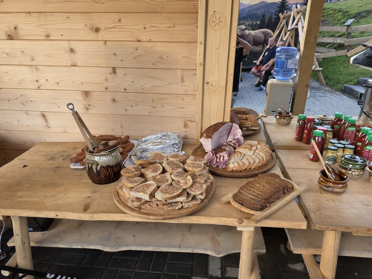 Drewniany stół z chlebem, wędliną, smalcem i dodatkami